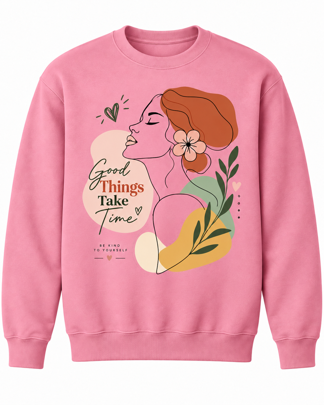 A pink crewneck sweatshirt featuring a colorful graphic illustration of a woman in profile with the text 'Good Things Take Time' and 'Be Kind to Yourself' printed on the front.