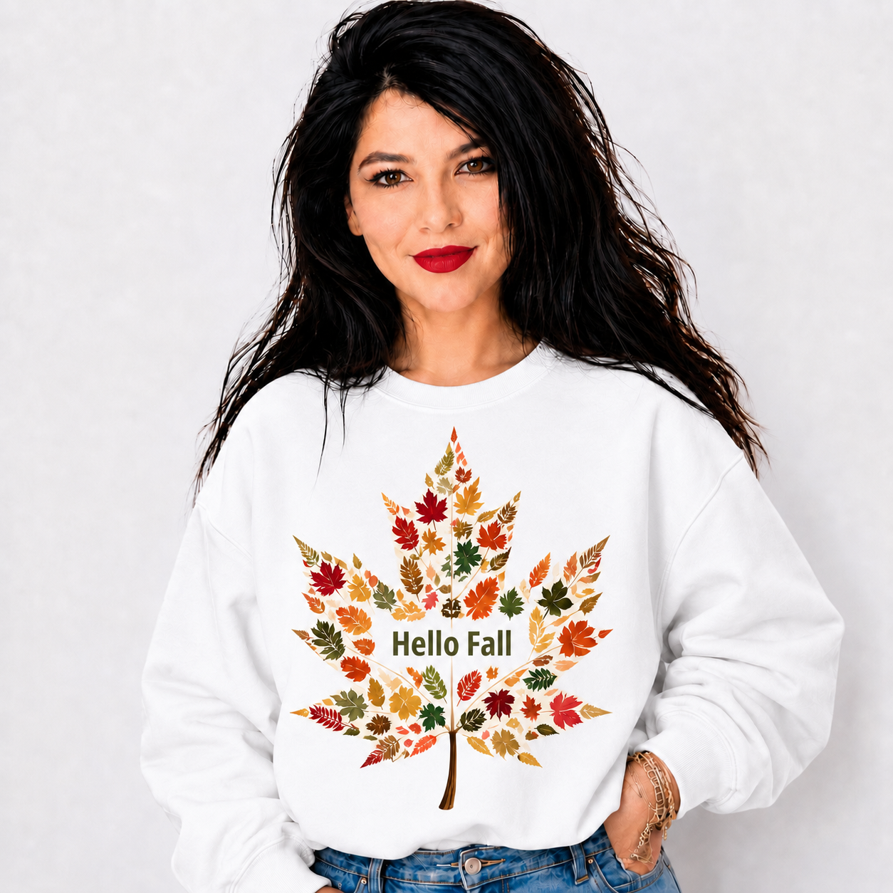 Featuring a large maple leaf made from colorful fall foliage in warm shades of orange, red, gold, green, and brown, this design brings seasonal charm to an easy everyday look. The soft white crewneck style makes the artwork stand out beautifully and pairs well with jeans, leggings, or casual fall layers.

