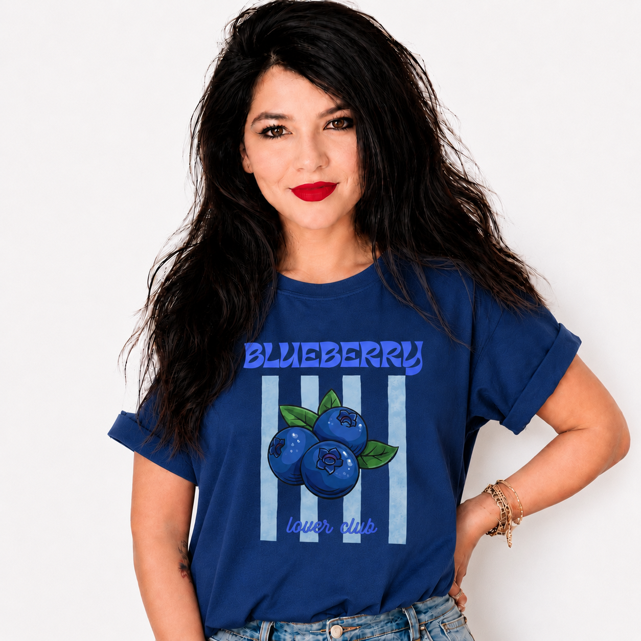 A woman with long dark hair wearing a blue graphic t-shirt featuring blueberries and the text 'BLUEBERRY lower class' on a white background.