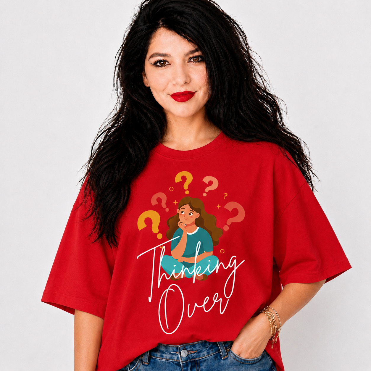 A woman with long black hair wearing a red graphic t-shirt that says 'Thinking Over' with an illustration of a woman surrounded by question marks, paired with blue jeans, against a light gray background.